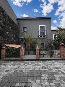 a house with a brick wall and a fence at Il Casale del 900 in Catania