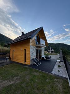 a log cabin with a deck and a patio at Marcinówka - Górski Domek w Gorcach in Tylmanowa