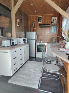 a kitchen with white appliances and a table and chairs at Lombfészek in Rezi