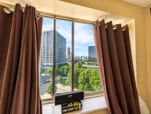 a window with brown curtains and a view of a city at Beautiful 3BR Condo in DTWN Pool Access in Atlanta