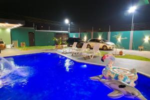 a swimming pool with a toy dolphin in a parking lot at Quinta Heluue in Ciudad del Este