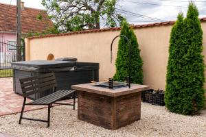 a barbecue grill and a bench in a backyard at Crystalapartmanhaz in Gyula