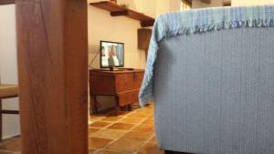 カソルラにあるAlojamiento rural La Casillaのリビングルーム(青い椅子、デスク付)