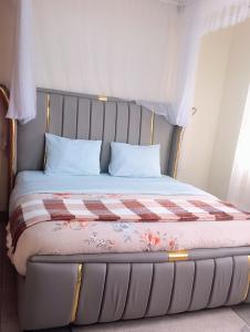 a bed with a metal frame with a blanket on it at Spea Residency Apartment in Mbarara