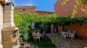 a patio with a table and chairs and vines at Casa Rural Lutia in Andaluz