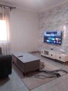 a living room with a tv on a stone wall at Spea Residency Apartment in Mbarara