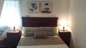カソルラにあるAlojamiento rural La Casillaのベッドルーム1室(ベッド1台、ナイトスタンド2台、ランプ2つ付)