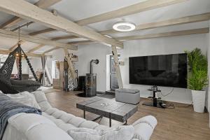 a living room with a white couch and a tv at Golden Grey Loft Bahrenfeld Volkspark Hamburg in Hamburg