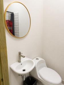 a bathroom with a white toilet and a mirror at Hotel Castillo in San Pedro Sula