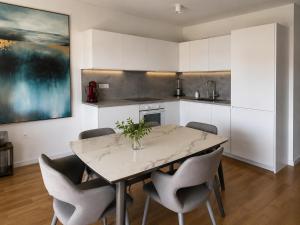 a kitchen with a table and chairs in a room at Vila Ester - apartman Lovrana in Lovran