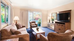 a living room with couches and a flat screen tv at Inn by the Harbor in Santa Barbara