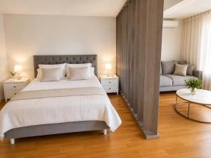 a bedroom with a large bed and a couch at Vila Ester - apartman Lovrana in Lovran
