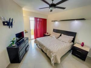 a bedroom with a bed and a ceiling fan at Hotel Bogavante in Barra de Navidad