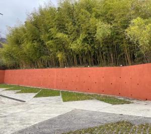 a red fence with trees in the background at Vila Ester - apartman Lovrana in Lovran +1 photo