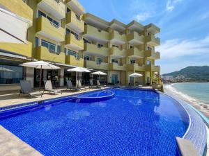 a hotel with a swimming pool next to the ocean at Hotel Bogavante in Barra de Navidad