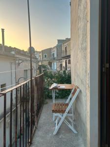 Ein Tisch und ein Stuhl stehen auf einem Balkon in der Unterkunft Maltese16 in Modica