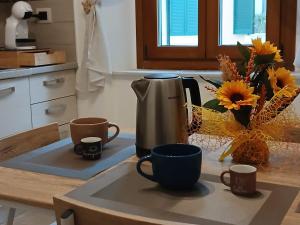 a kitchen counter with cups and a coffee maker on it at Chimera 37 in Avezzano
