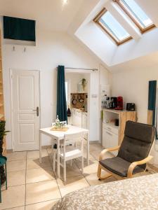 a room with a table and a chair and a kitchen at Studio Terrasse - Parking gratuit in Orléans