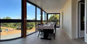 a dining room with a table with chairs and large windows at Gîte Chez Clara in Rocamadour