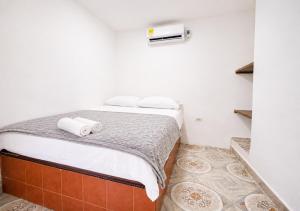 a bedroom with a bed with two towels on it at O C E A N B L U E Hotel Bahia in Santa Marta