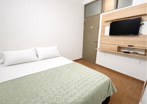 a bedroom with a bed and a flat screen tv at O C E A N B L U E Hotel Bahia in Santa Marta