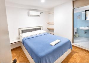 a bedroom with a bed and a bathroom with a sink at O C E A N B L U E Hotel Bahia in Santa Marta