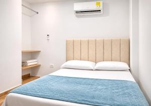 a bedroom with a bed with a blue blanket at O C E A N B L U E Hotel Bahia in Santa Marta