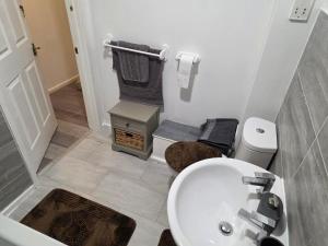 a bathroom with a white sink and a toilet at 2bdr Ground Floor Flat in Edmonton free Parking and WiFi in Ponders End