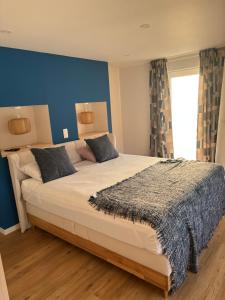 a bedroom with a large bed with a blue wall at Maison des W in Jalhay