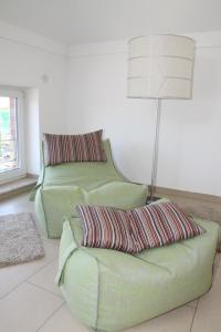 a living room with two green chairs and a lamp at Allegra am Niederrhein in Neukirchen-Vluyn