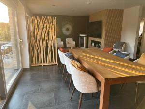 a dining room with a wooden table and chairs at Maison des W in Jalhay