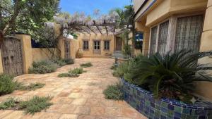 a house with a courtyard with plants in front of it at Hotel Sakthi-Pallava Shore's in Mahabalipuram