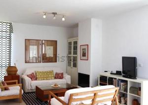 a living room with a white couch and a tv at Preciosa duplex en el Rompido in El Rompido