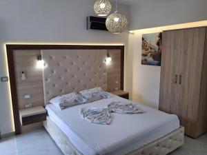 a bedroom with a large white bed with a headboard at Studio Apartments Tea in Sutomore