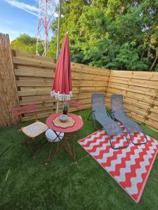 a patio with a table and chairs and an umbrella at Le relax & vous in La Louvière