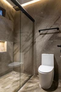 a bathroom with a toilet and a glass shower at Hotel Alma Boutique in Jiutepec