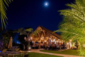 a group of people sitting outside of a building at night at Hotel Alma Boutique in Jiutepec