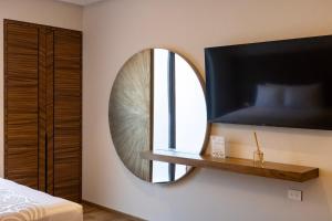 a bedroom with a mirror and a tv at Hotel Alma Boutique in Jiutepec