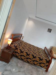 a bedroom with a bed with a lamp on a table at Salamandre in La Salamandre