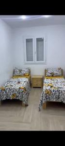 a room with two beds and a table and two windows at Salamandre in La Salamandre
