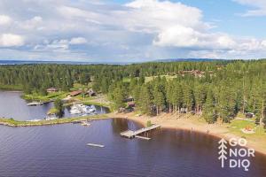an aerial view of a lake with a dock and a beach at The Red Deer Lodge in Tällberg