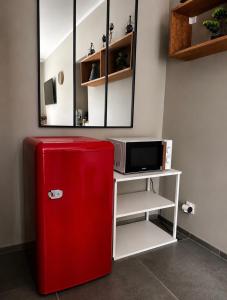 a red refrigerator in a room with a mirror at Chambre style hôtel in Sablet