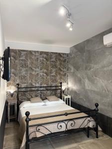 a bedroom with a black bed and a wall mural at Bassa Marea in Nettuno
