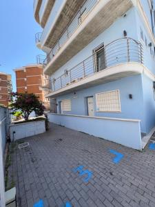 a building with blue drawings on the ground in front of it at Bassa Marea in Nettuno