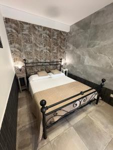 a bedroom with a bed with a stone wall at Bassa Marea in Nettuno