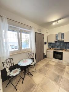 a kitchen with a table and two chairs and a table at Bassa Marea in Nettuno