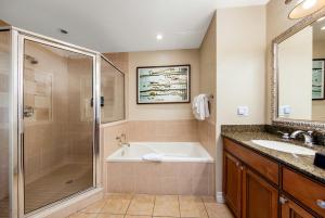 a bathroom with a tub and a shower and a sink at WorldMark Reunion in Kissimmee