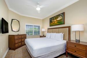 a bedroom with a large white bed and a mirror at WorldMark Reunion in Kissimmee