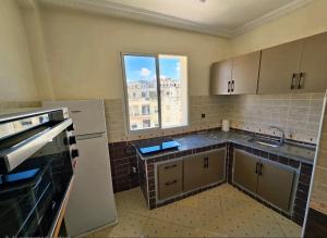 an empty kitchen with a sink and a window at Morjan apart in Tangier