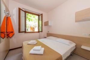 a bedroom with a bed with two towels on it at Bungalow 2 2 in Sirmione +54 photos